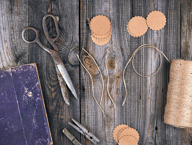 棕色绳索纸标签和灰色木背景的旧剪刀用于制作手工艺品的物图片