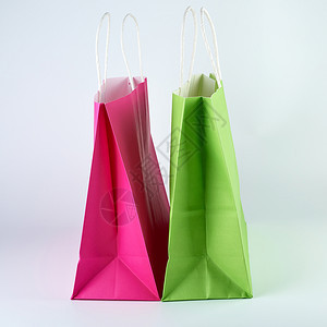 长方形粉和绿纸购物袋有白色背景的手柄关闭图片