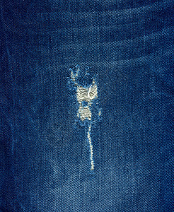 蓝色牛仔裤布的碎片一个洞完整的框架关闭图片