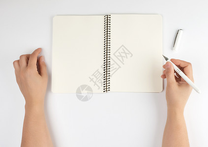 两只手握着女持张开的笔记板在白背景顶视图上用干净的床单保存在白背景上图片