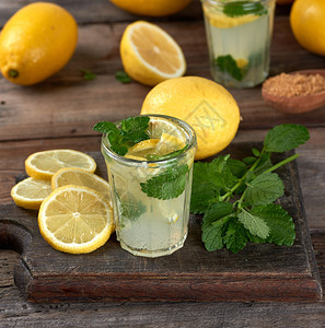 柠檬汁加薄荷叶放在杯子里与鸡尾酒的配料旁边图片