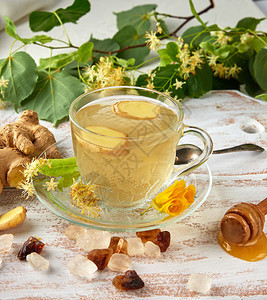 茶杯透明来自姜和叶子在白木板上顶面图片