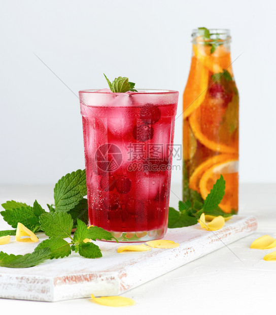 夏季清新饮料用红莓浆果和冰块在一木板上的玻璃杯中白底图片