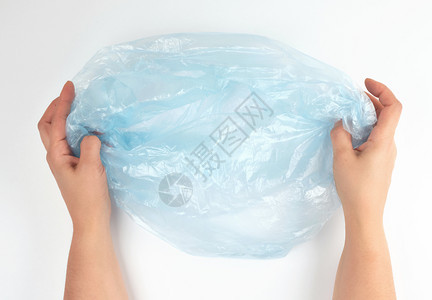 女手中的蓝色塑料垃圾袋白色背景顶视面图片