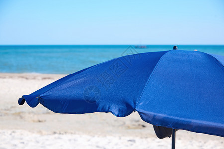 在沙海岸上露天蓝纺织品海滩伞度假概念图片