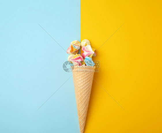 蓝色黄背景的华夫饼杯中多颜色的烤蛋白图片