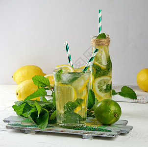 柠檬汁加薄荷叶玻璃中的石灰与鸡尾酒的原料相邻图片