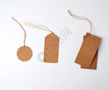 圆形棕褐色纸价标签挂在白色背景的绳索上图片