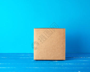 蓝色背景的封闭方形棕色礼品盒关闭图片