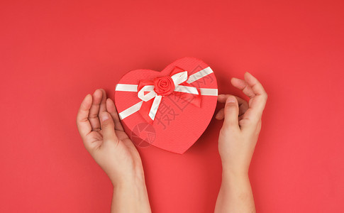 两手握着一张纸封闭的红箱背景节日心脏的形状图片