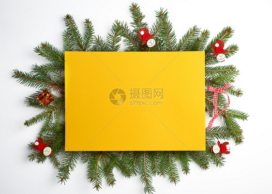 祝贺圣诞背景空黄色纸片和绿树枝配有白的节日玩具图片