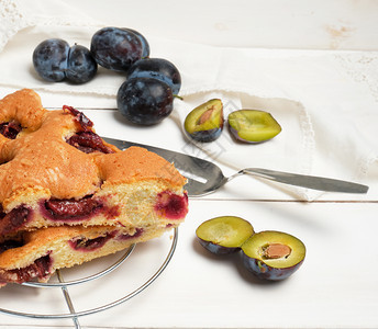白木板和新鲜水果上的饼干李子蛋糕片图片