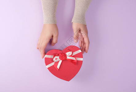 两手握着一张纸封闭的红盒以心脏形状喜庆背景图片