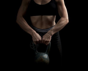 运动女员的外貌孩面前拿着铁壶铃体力运动低键图片
