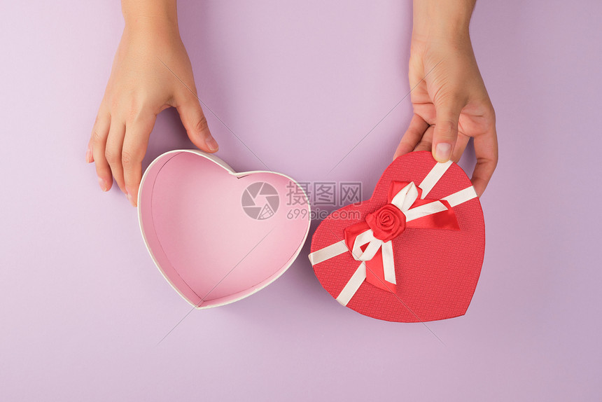 两只女手握着一个开阔的沙漠红心形盒子喜庆背景图片