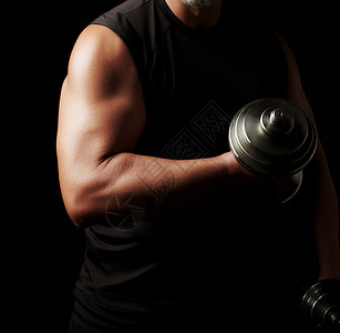 穿黑衣服的成年男子手上握着钢铁哑铃肌肉紧张低钥匙运动背景图片