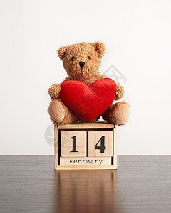 2月14日的立方木历和黑桌上的棕色泰迪熊情人节庆祝活动图片
