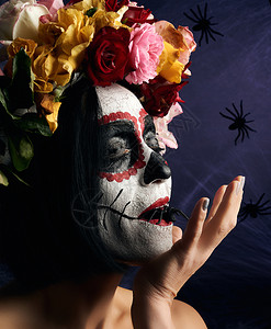带着传统的墨西哥人面具的年轻美少女CalaveraCatrina糖头盖化妆穿着白网背景玫瑰花圈的女孩图片