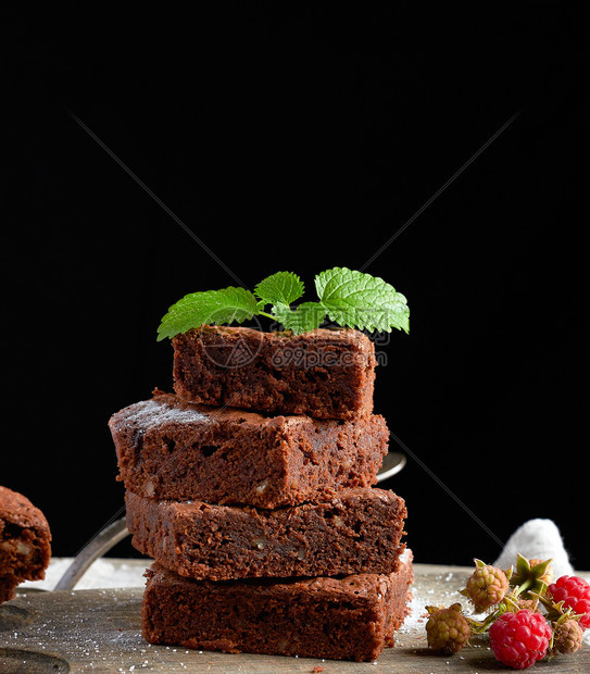 黑底棕色木切板上的巧克力蛋糕图片
