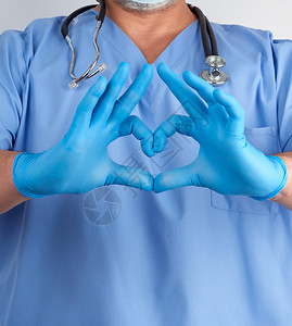穿蓝色制服和乳胶手套的医生在胸前有心脏手势白色背景胸前有心脏手势图片