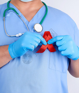 蓝制服医生和无菌乳胶手套戴着抗击艾滋病和血管炎的红丝带标本图片
