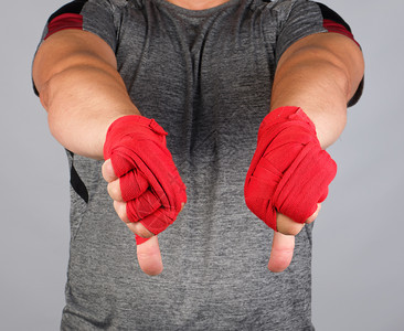 身穿灰制服的成年运动员和手满的纺织红色绷带显示手势不喜欢白色背景图片