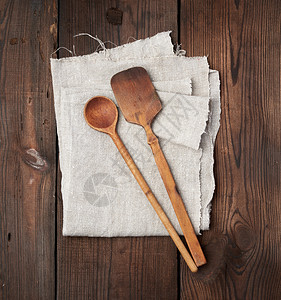 灰色纸巾上的木制旧勺子和毛片顶视图图片