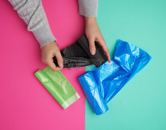 黑塑料袋用于垃圾绿色粉红背景图片