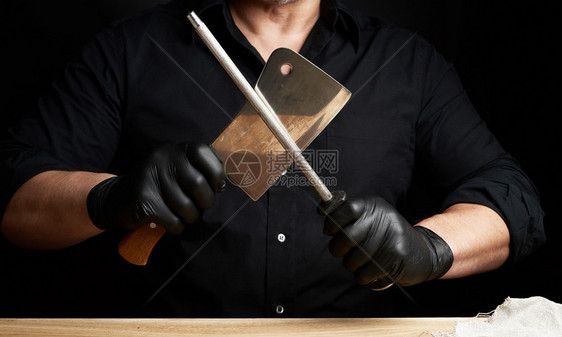 黑衬衫和乳胶手套的厨师用餐桌上的把手低键关上图片