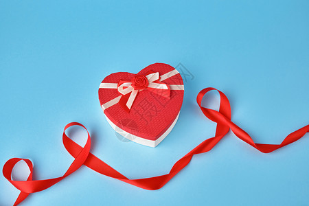 红色心形礼物盒蓝色背景的弓顶部视图节日背景情人礼物图片