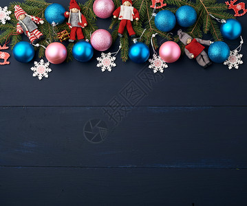 绿色树枝圣诞蓝球和粉红木板上蓝背景的雕装饰复制空间图片
