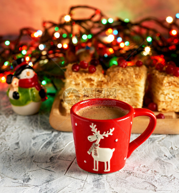 红陶瓷杯加黑咖啡靠近绿枝的葡萄酒和圣诞玩具饮料图片