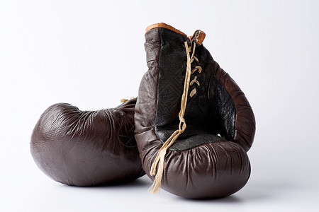 白色背景的旧棕拳击手套运动设备健身房背景图片