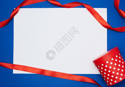蓝色背景测试地点假日背景上的白纸和红色丝绸带图片