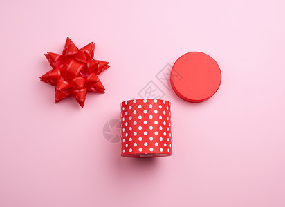 圆红色纸箱白波尔卡圆点在粉红背景假日的弓顶上图片
