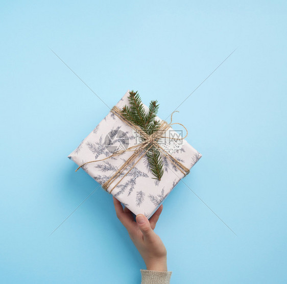 女手拿着一张蓝色背景的纸盒图片