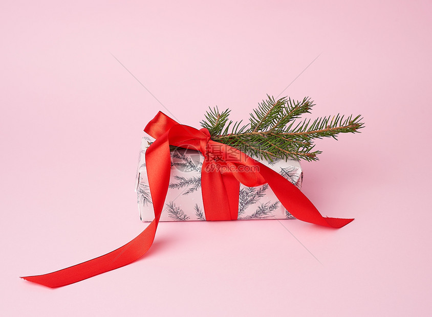 粉红色包裹的礼品盒绑在红弓粉色假日背景上图片