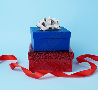 蓝色背景喜庆上包着结的弓包着礼物堆叠图片