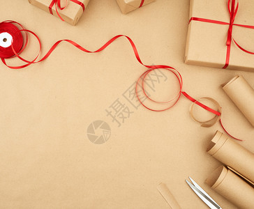 棕色牛皮纸包装好的礼品袋系上红丝带一套礼品包装设计复制空间图片