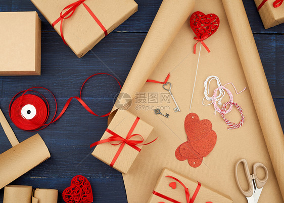 棕色克拉夫纸包装的礼品袋并绑上红色丝带心一套用手做礼物的品图片