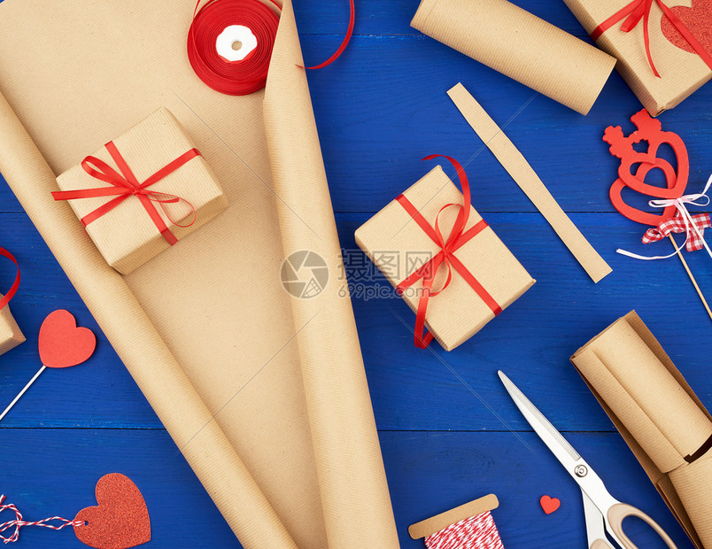 棕色克拉夫纸包装的礼品袋并绑上红色丝带心一套用手做礼物的品图片