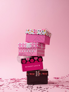 粉红背景的纸板广场礼品盒堆叠式纸板彩色背景闪亮的面彩喜庆背景图片