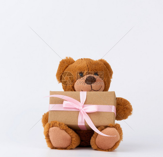 可爱的棕色小泰迪熊拿着一个棕色盒子白底带有粉色丝图片