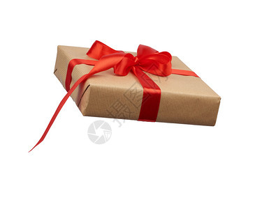方形框用棕色克拉夫纸包裹绑上丝绸红色带侧观白色背景的礼物图片