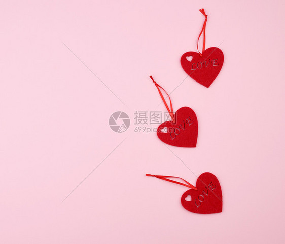 3个红心在粉背景上庆祝假日的概念图片