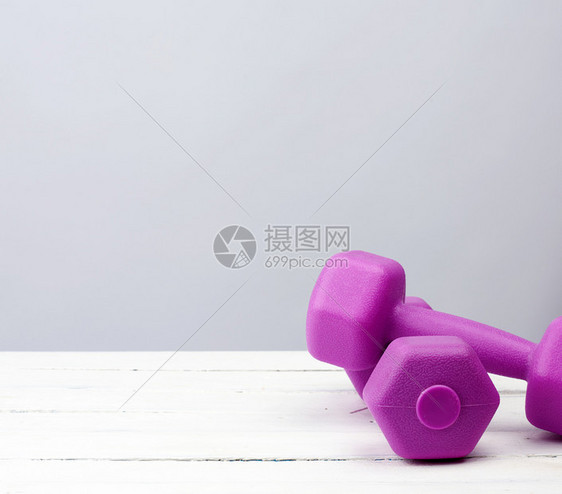 一对紫色塑料哑巴运动用白色背景健身训练康的生活方式图片
