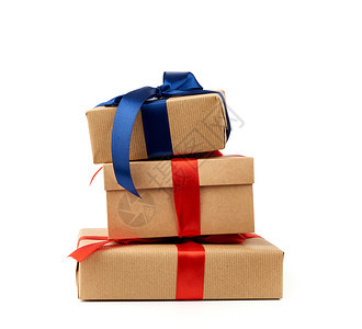 包裹在棕色KKraft纸上并绑有丝绸蓝和红带白背景孤立的盒子设计师要素图片
