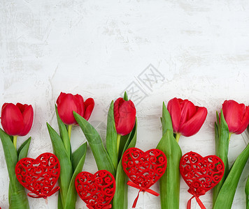 白水泥背景的红开花郁金香束有绿色的根茎叶子和红心生日情人节周年纪念的喜庆背景图片