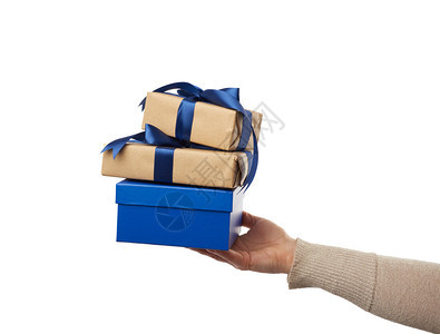 手握包装的礼品用棕色手纸包着有捆绑的丝弓主题在白色背景惊喜概念和节日礼物上被孤立图片