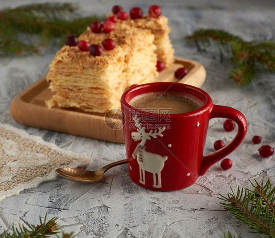 红陶瓷杯黑咖啡和一小片面饼拿破仑奶油装饰与红莓喜庆背景图片